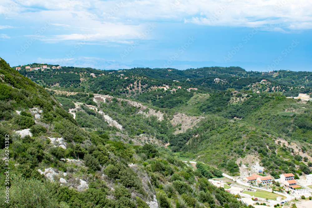 View of the greeny inland of Corfu island with mountains in Albania in the background