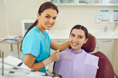 Dentist and woman patient smiling during teeth examination in dentist office