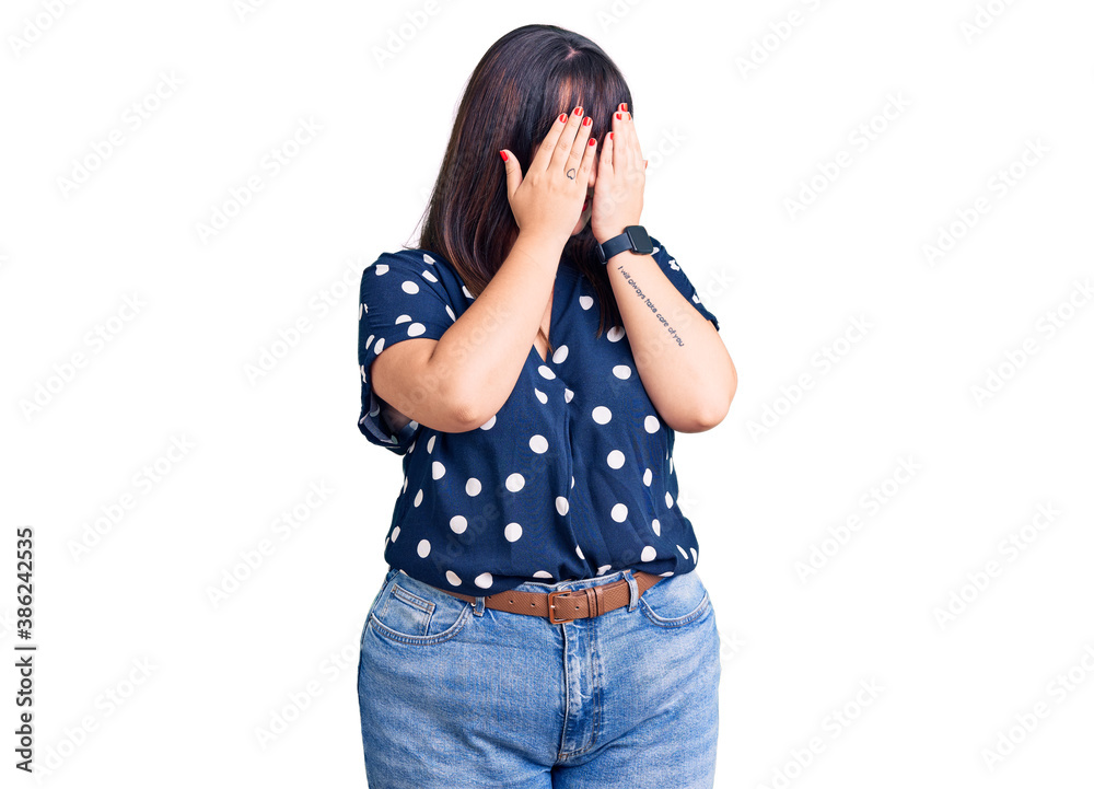 Young plus size woman wearing casual clothes with sad expression covering face with hands while crying. depression concept. Young plus size woman wearing casual clothes with sad expression covering face with hands while crying. depression concept.