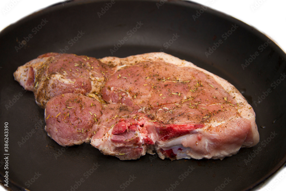 Fresh raw pork steak with spices roasting on frying pan Fresh raw pork steak with spices roasting on frying pan