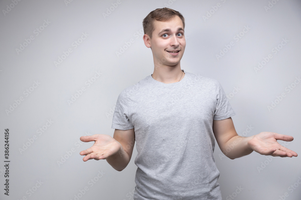 Studio portrait concept of a smiling young man talking on a white background. He stands directly in front of the camera in different poses with different emotions. Studio portrait concept of a smiling young man talking on a white background. He stands directly in front of the camera in different poses with different emotions.
