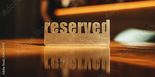 Fotografie metal sign reserved on a wooden table in a cafe