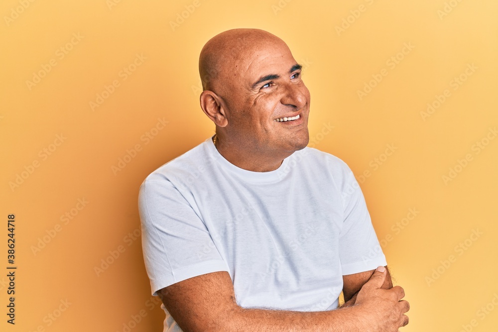 Mature middle east man wearing casual white tshirt looking away to side with smile on face, natural expression. laughing confident. Mature middle east man wearing casual white tshirt looking away to side with smile on face, natural expression. laughing confident.