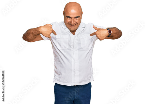 Mature middle east man with mustache wearing casual white shirt looking confident with smile on face, pointing oneself with fingers proud and happy. © Krakenimages.com