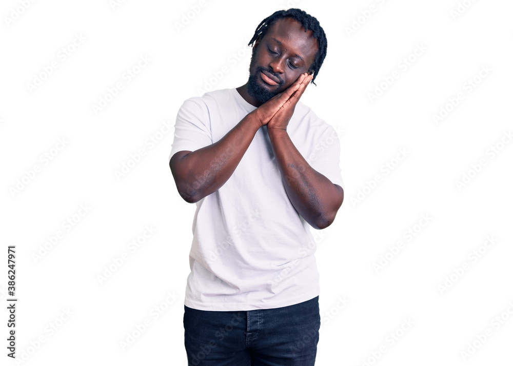 Young african american man with braids wearing casual white tshirt sleeping tired dreaming and posing with hands together while smiling with closed eyes. Young african american man with braids wearing casual white tshirt sleeping tired dreaming and posing with hands together while smiling with closed eyes.