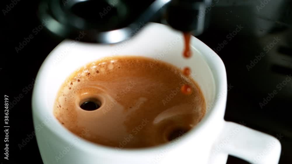 Close-up Slow Motion of Espresso Pouring from Coffee Machine. Filmed on High Speed Cinematic Camera at 1000 fps.