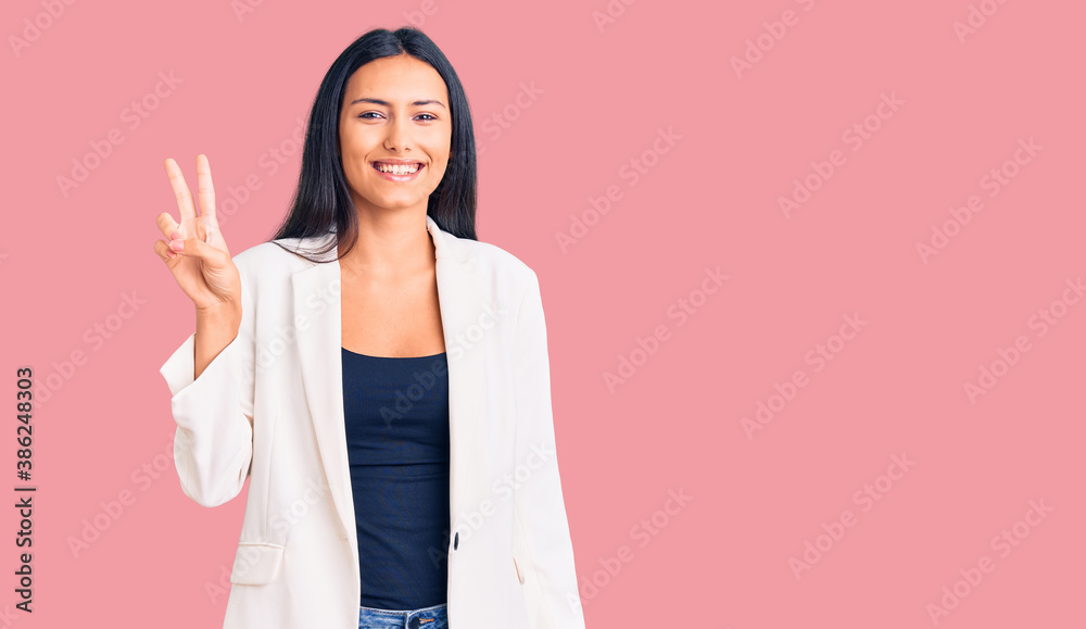 Young beautiful latin girl wearing business clothes smiling with happy face winking at the camera doing victory sign. number two. Young beautiful latin girl wearing business clothes smiling with happy face winking at the camera doing victory sign. number two.
