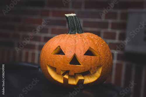 Halloween pumpkin on a brick wall background. Darkened background.