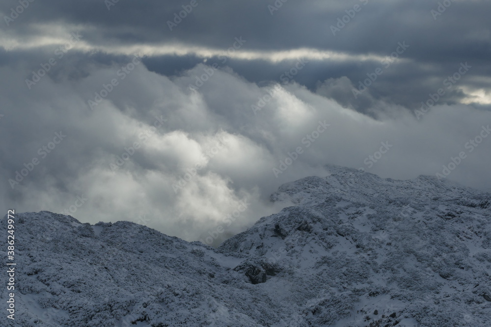 Wolken in den verschneiten Bergen