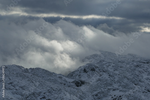 Wolken in den verschneiten Bergen