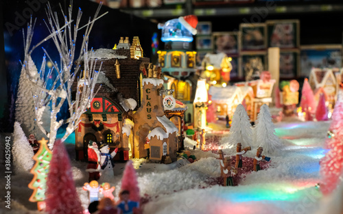 Santa Clause house, xmas holidays, Christmas time, street in snow, miniature of winter scene with houses, people, trees, Christmas concept. © tselykh