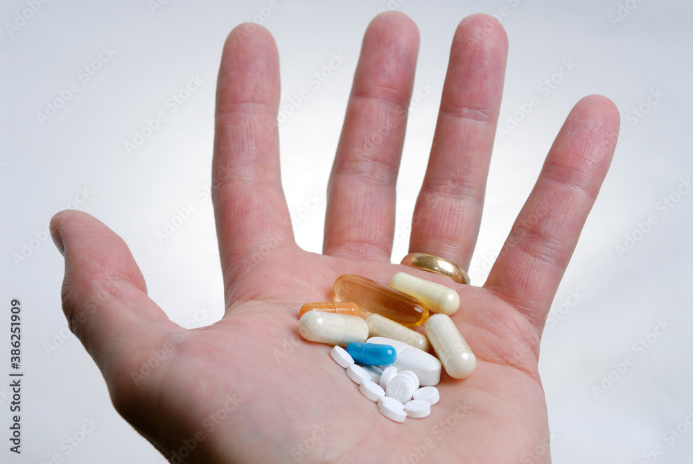 Outstretched hand with assortment of pills Outstretched hand with assortment of pills