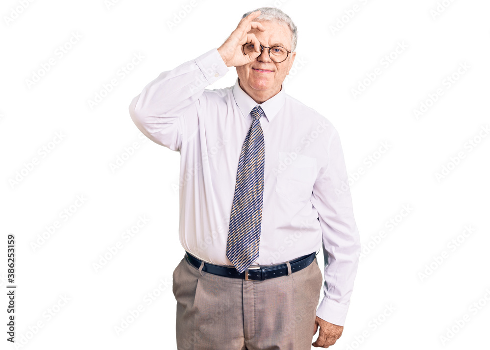 Senior grey-haired man wearing business clothes doing ok gesture with hand smiling, eye looking through fingers with happy face. Senior grey-haired man wearing business clothes doing ok gesture with hand smiling, eye looking through fingers with happy face.