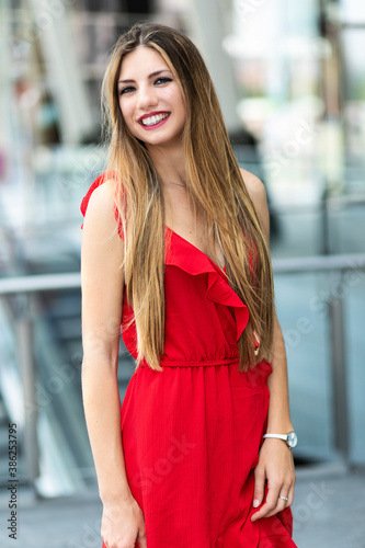 Beautiful woman in a red dress smiling outdoor