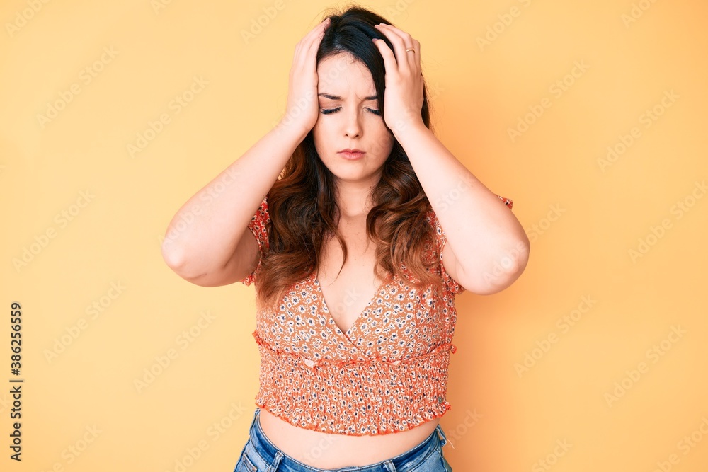 Young beautiful brunette woman wearing casual summer clothes suffering from headache desperate and stressed because pain and migraine. hands on head.