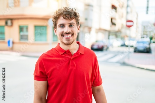 Young handsome caucasian man smiling happy walking at city.