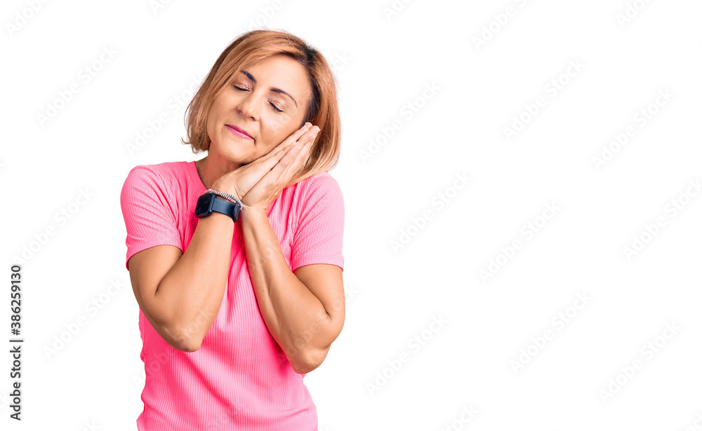 Young blonde woman wearing sportswear sleeping tired dreaming and posing with hands together while smiling with closed eyes. Young blonde woman wearing sportswear sleeping tired dreaming and posing with hands together while smiling with closed eyes.
