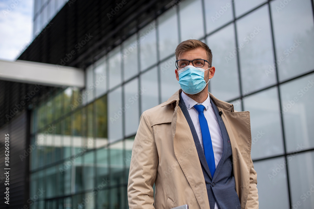 Businessman leaves the office with face mask protect from Coronavirus or COVID-19, global crisis, safety first Businessman leaves the office with face mask protect from Coronavirus or COVID-19, global crisis, safety first