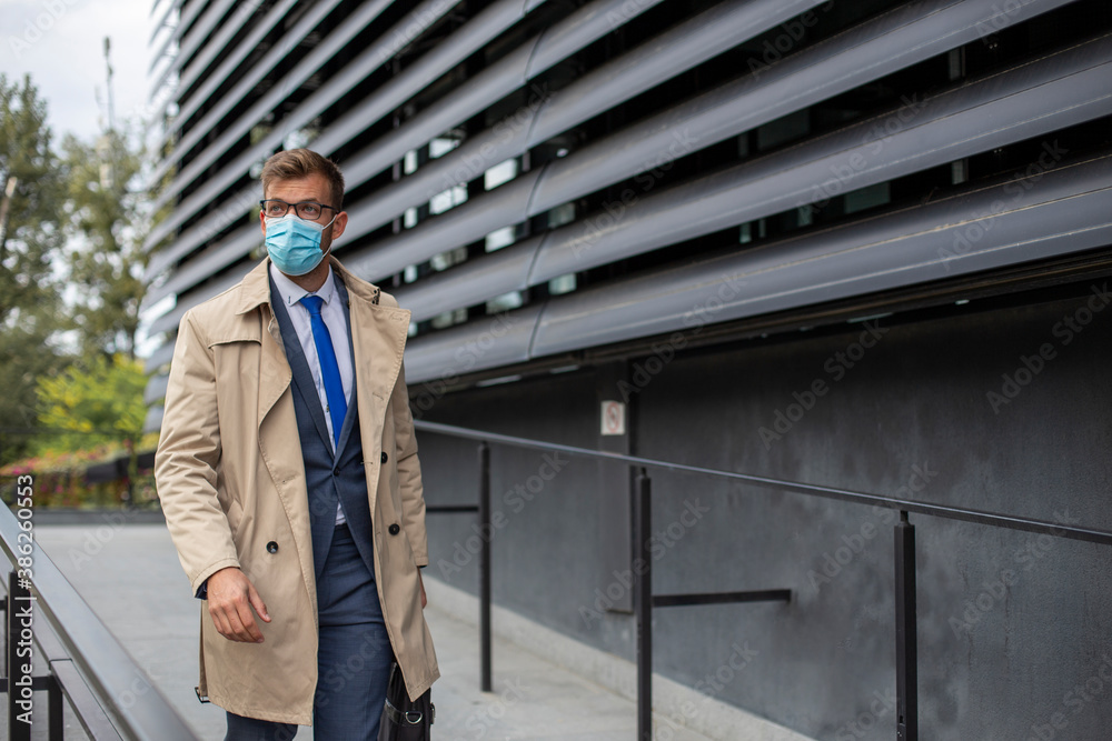 Businessman leaves the office with face mask protect from Coronavirus or COVID-19