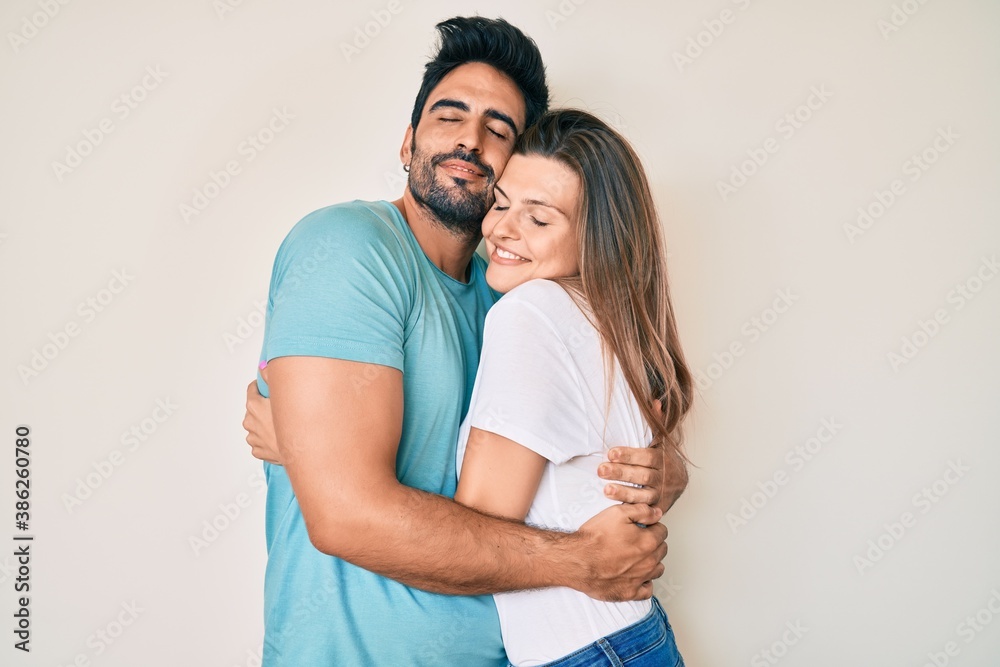 Naklejka premium Beautiful young couple of boyfriend and girlfriend together hugging oneself happy and positive, smiling confident. self love and self care