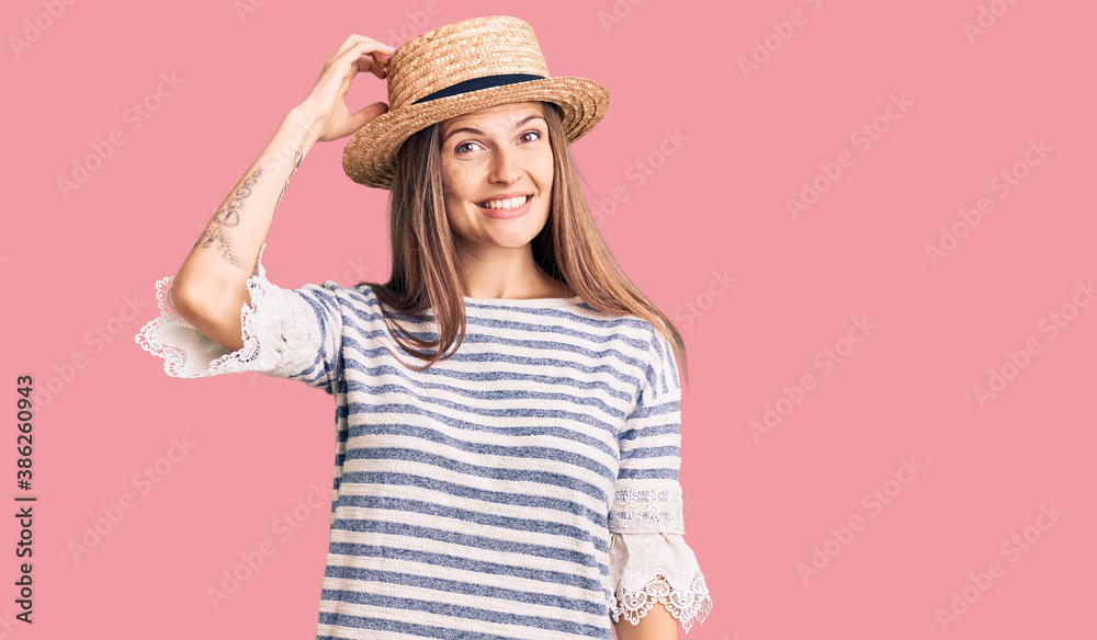 Beautiful caucasian woman wearing summer hat confuse and wonder about question. uncertain with doubt, thinking with hand on head. pensive concept. Beautiful caucasian woman wearing summer hat confuse and wonder about question. uncertain with doubt, thinking with hand on head. pensive concept.