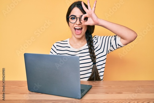 Photography Brunette teenager girl working using computer laptop smiling happy doing ok sign
