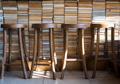 Row of wooden stools in front of wooden counter inside a vintage style bar © Aleksander