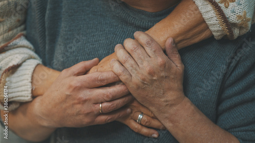 close up wrinkled hands. Happy old couple hugging in park. Senior man flirting with elderly woman. Romance at old age dancing on autumn day. High quality photo