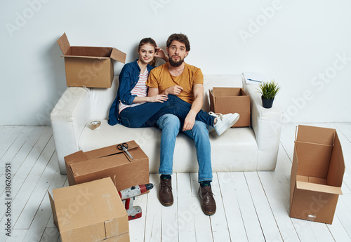 Young couple boxes with things on moving room interior © SHOTPRIME STUDIO