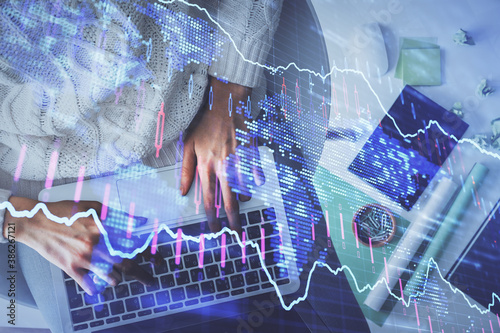 Multi exposure of woman hands working on computer and forex chart hologram drawing. Top View. Financial analysis concept.