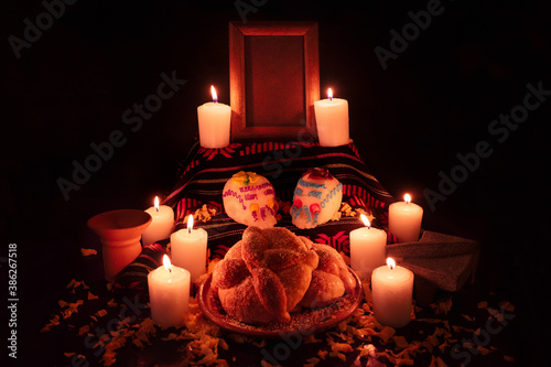 Mexican day of the dead altar with bread and sugar skulls on dark background