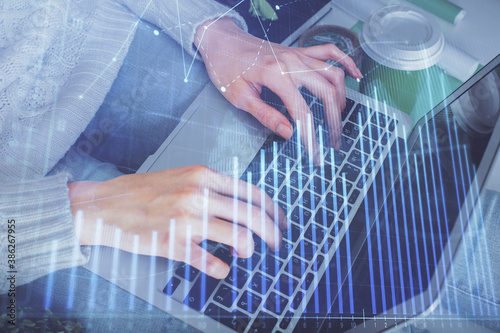 Double exposure of woman hands typing on computer and forex chart hologram drawing. Stock market invest concept.