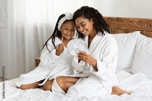 Beauty Day With Mom. Black Mother And Daughter In Bathrobes Applying Makeup