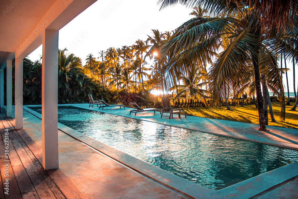 Fototapeta premium SUNSET IN THE CARIBBEAN, SEEN FROM THE POOL AREA OF A LUXURY VILLA