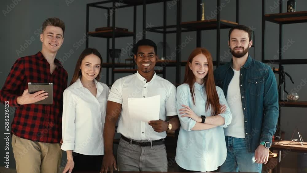 Portrait of successful smiling multi-ethnic business team in modern ...