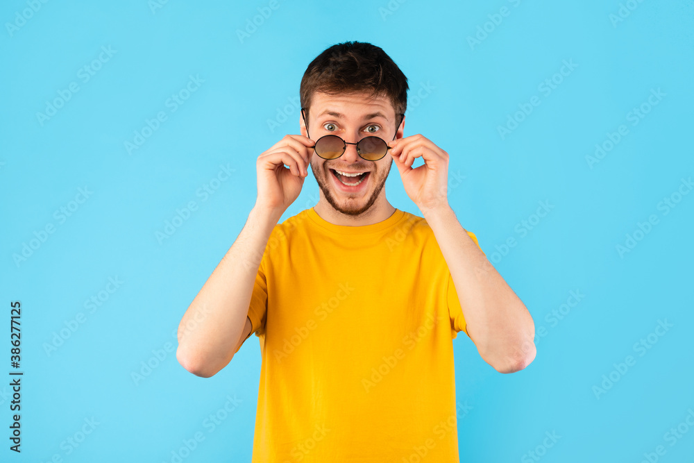 Excited surprised guy looking at camera taking off sunglasses Excited surprised guy looking at camera taking off sunglasses