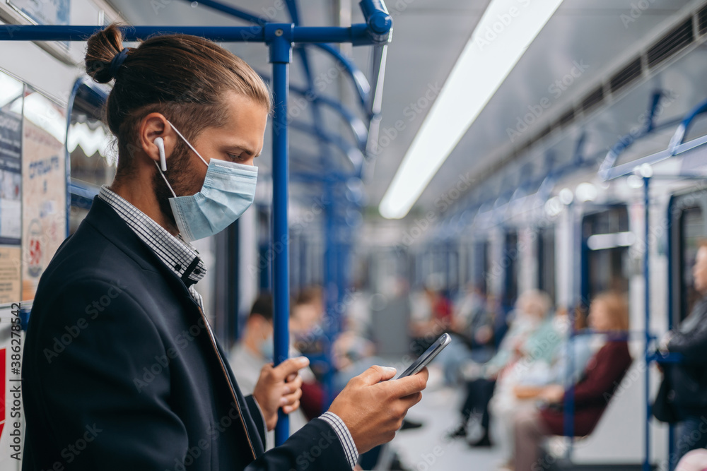 man in a protective mask standing in a subway car. man in a protective mask standing in a subway car.