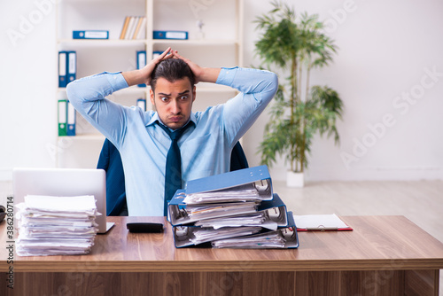 Young male businessman employee working in the office photo