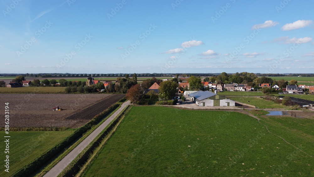 A very small place Oudemolen in Brabant near Willemstad. With drone taken photo of a village with a mill and farmlands around it.