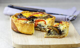Closeup view and selective focus to french tart quiche with mushrooms, eggplants, tomatoes and meet. 