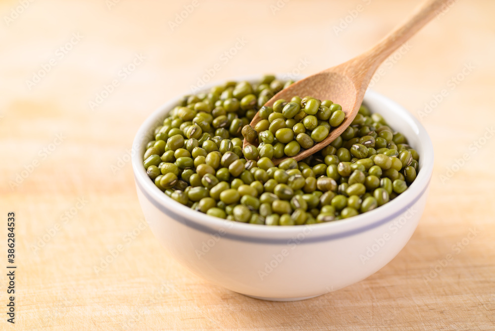 Mung bean with spoon in a bowl on wooden background Mung bean with spoon in a bowl on wooden background