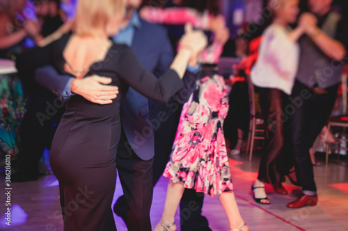 Couples dancing traditional latin argentinian dance milonga in the ballroom, tango salsa bachata lesson in the red lights, dance festival © tsuguliev