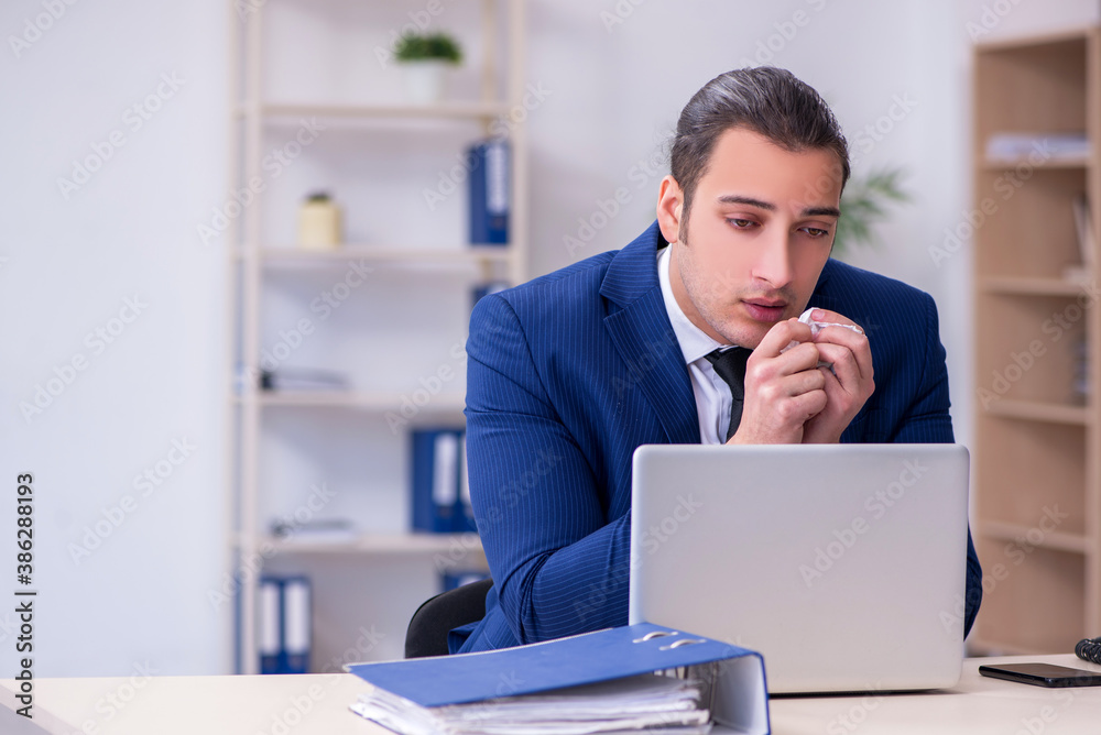 Sick male employee suffering at workplace Sick male employee suffering at workplace