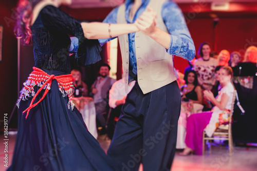 Couples and women wearing red skirts and dress dancing traditional gypsy dance in the ballroom hall