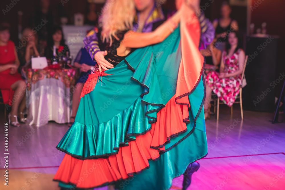 Couples and women wearing red skirts and dress dancing traditional gypsy dance in the ballroom hall