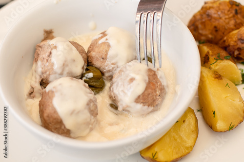 View of Koenigsberger klops,  a specialty traditional german style cooked meat balls in Kaliningrad, Kaliningrad Oblast, Russia, served with mashed potatoes in a white sauce with capers photo