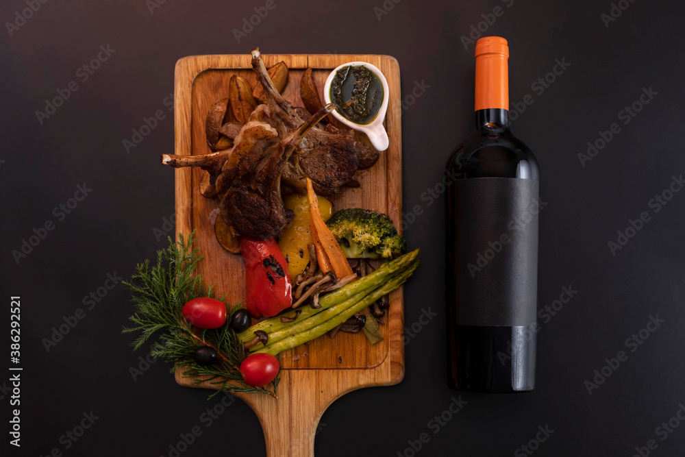 Bottle of wine lying down in black background with some food as