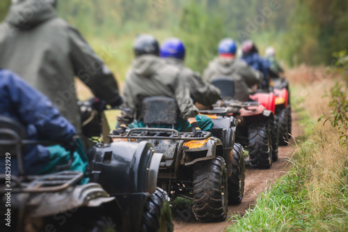 Group of riders riding atv vehicle on off road track, process of driving ATV vehicle, all terrain quad bike vehicle, during offroad competition, crossing a puddle of mud