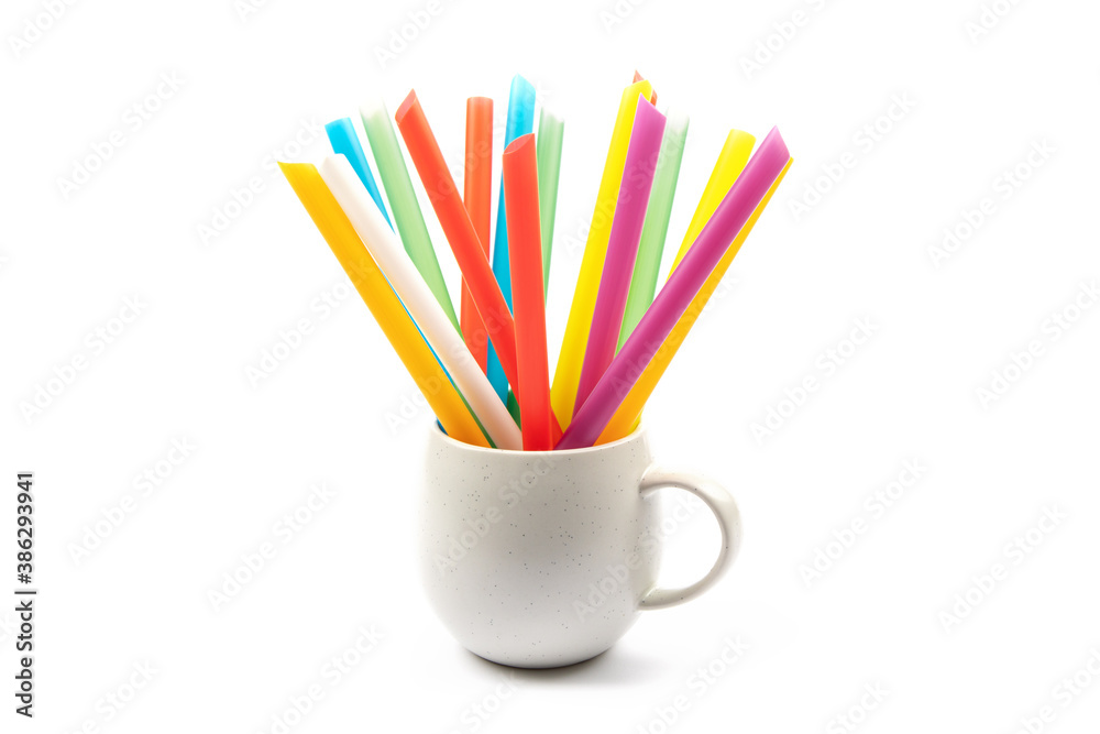 A coffee cup filled with colorful single use plastic straws A coffee cup filled with colorful single use plastic straws