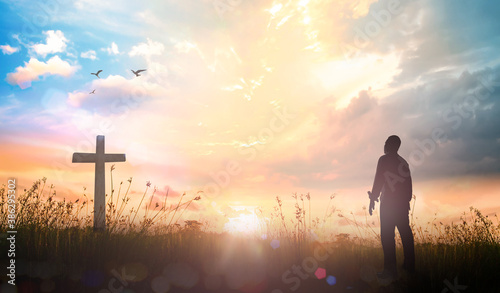 Vászonkép Resurrection of Easter Sunday concept: Silhouette christian over cross meadow su